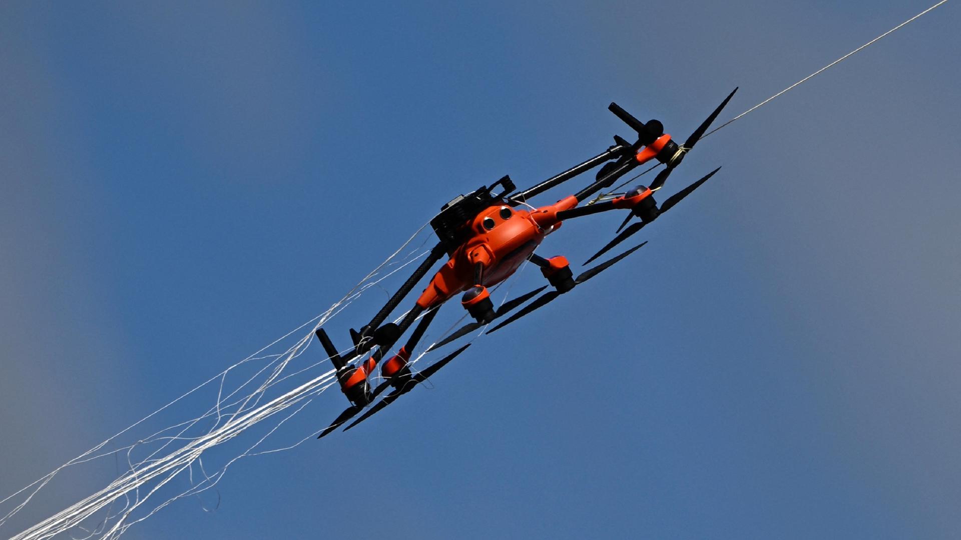 Eine Drohne wird mit einem von einer anderen Drohne geworfenen Netz gefangen. Eine Drohne wird mit einem von einer anderen Drohne geworfenen Netz gefangen.