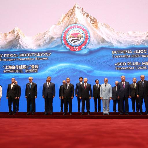 Die Mitglieder der SCO stehen für ein Gruppenfoto vor einer Wand, auf der ein weißer Berg zu sehen ist, zusammen.