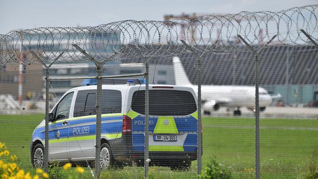  Eine Patrouille der Polizei am Stuttgarter Flughafen hinter einem Zaun.