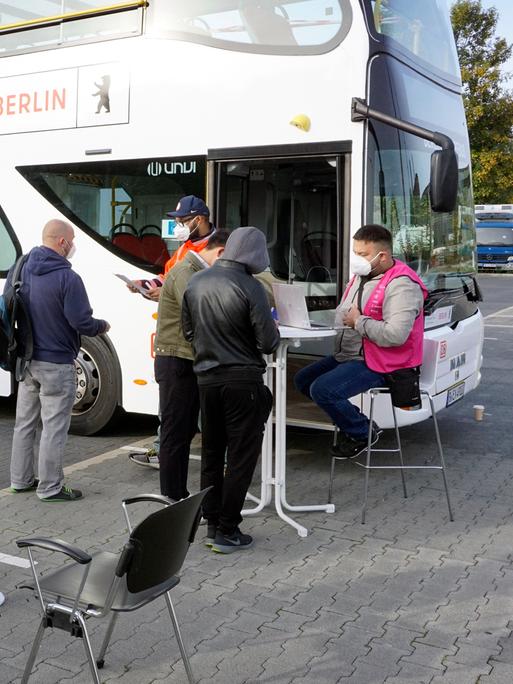 Menschen warten vor einem Berliner Impfbus am Dong Xuan Center im Berliner Stadtteil Lichtenberg. 