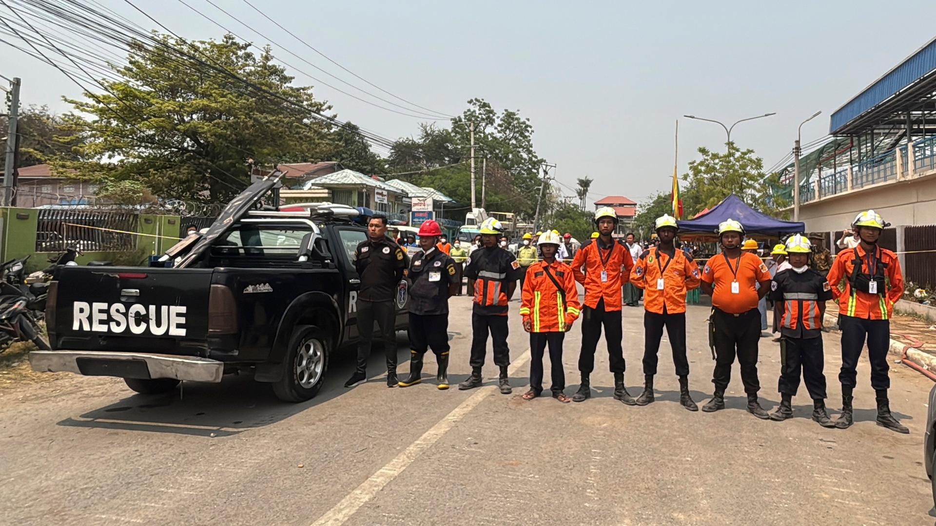 Rettungskräfte stehen während der Schweigeminute nebeneinander auf einer Straße in Mandaly in Myanmar. Rettungskräfte stehen während der Schweigeminute nebeneinander auf einer Straße in Mandaly in Myanmar.