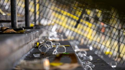 Leere Becher liegen auf der Tribüne eines Fußballstadions.  