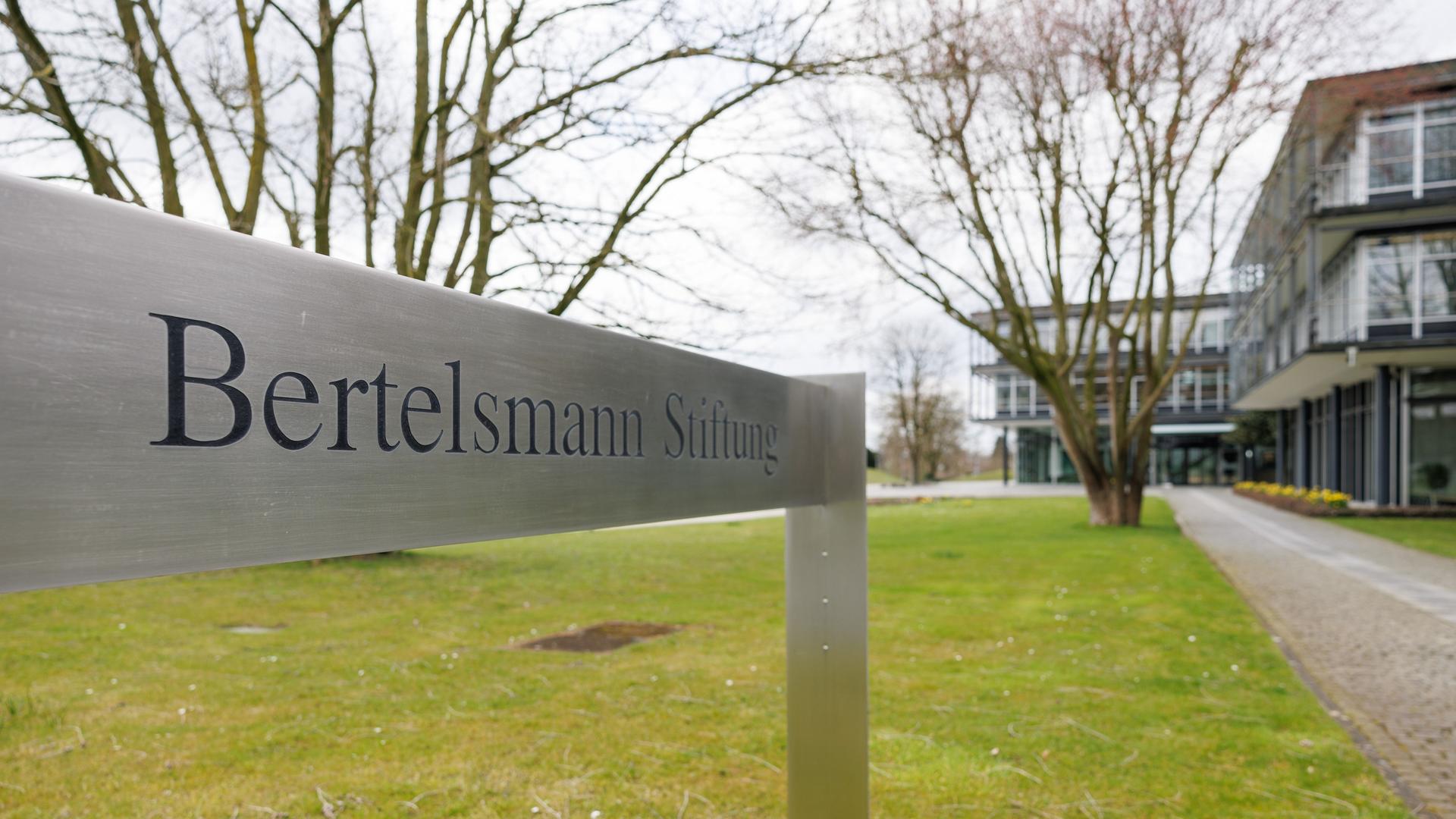 Blick auf ein Schild "Bertelsmann Stiftung" - im Hintergrund ist verschwommen ein Gebäudekomplex zu sehen Blick auf ein Schild "Bertelsmann Stiftung" - im Hintergrund ist verschwommen ein Gebäudekomplex zu sehen