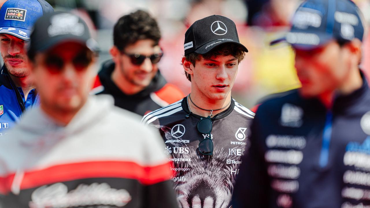 Der Formel-1-Pilot Kimi Antonelli beim Rennen in Suzuka in der Bildmitte. Um ihn herum sind weitere Personen unscharf abgebildet.