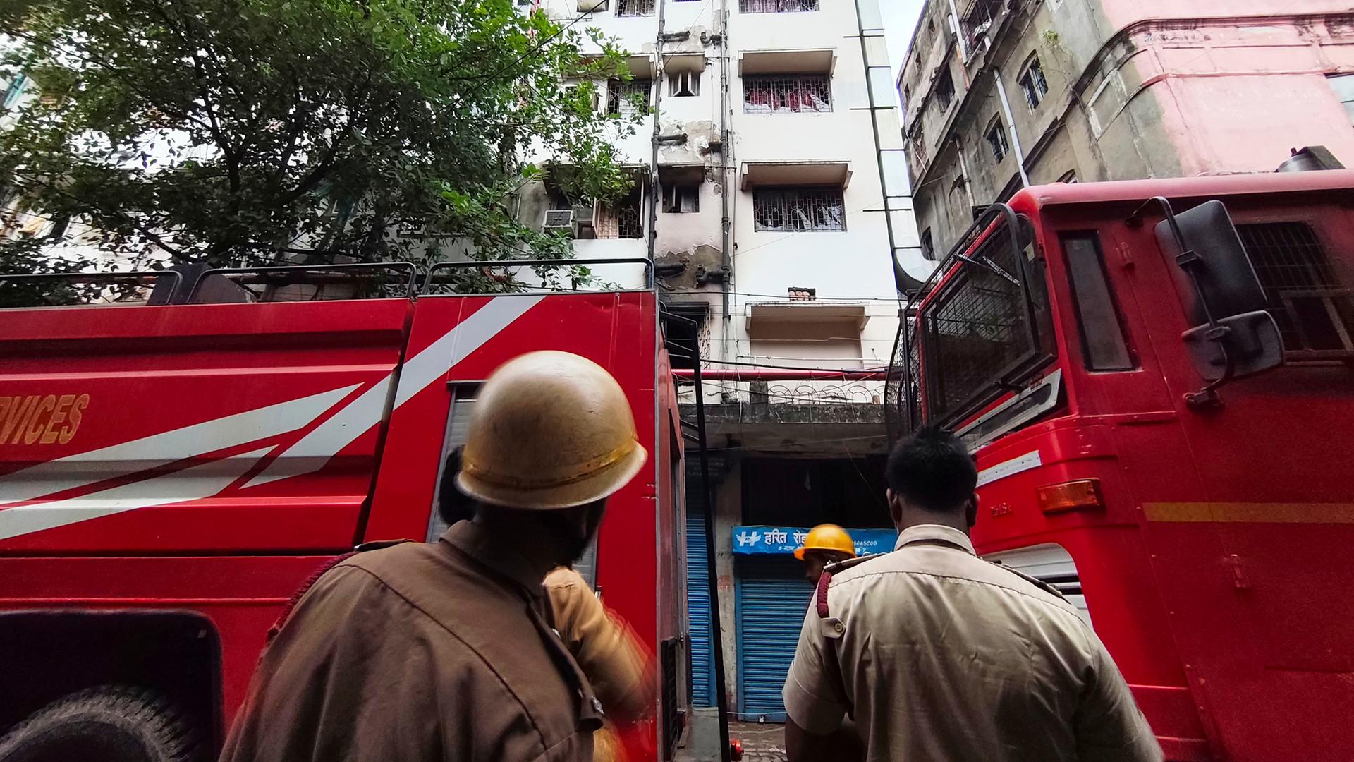 Feuerwehrleute stehen vor dem Hotel in Kolkata, Indien, das in Brand geraten war.