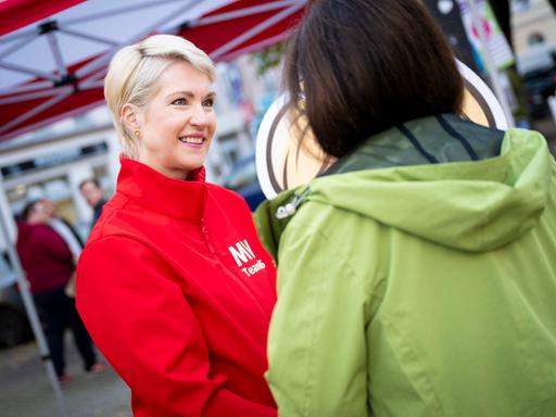 Manuela Schwesig (SPD) an einem Wahlkampfstand im Gespräch mit einer Passantin