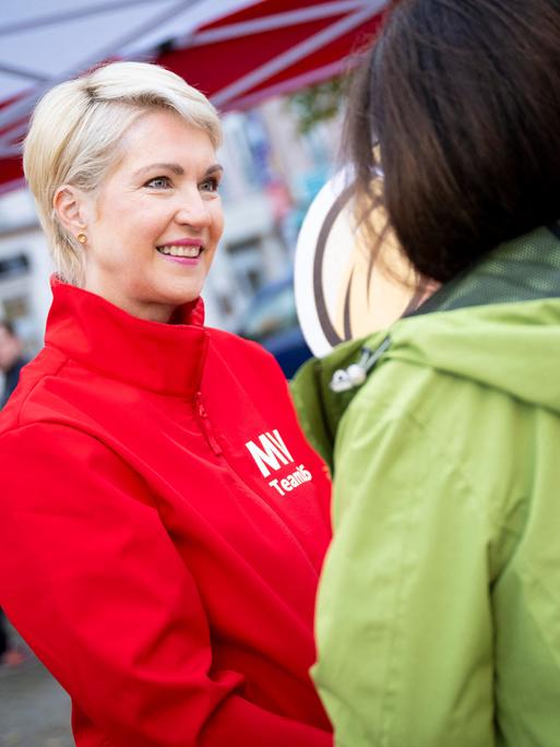 Manuela Schwesig (SPD) an einem Wahlkampfstand im Gespräch mit einer Passantin