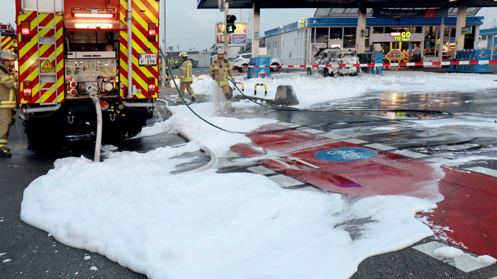 Löschschaum liegt nach dem Einsatz der Feuerwehr auf dem Gelände einer Tankstelle. 
