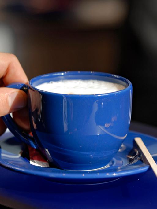 Mann hält eine Tasse Kaffee in der Hand