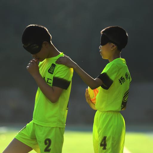 Blinde Kinder spielen in China Fußball mit einem klingenden Ball. 