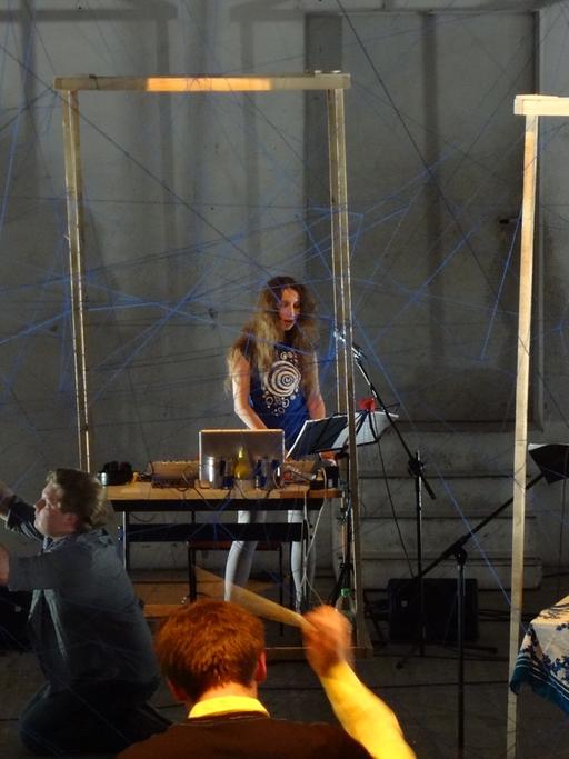 Die Komponistin Anna Korsun steht vor einem Laptop und spielt ein Konzert. 
