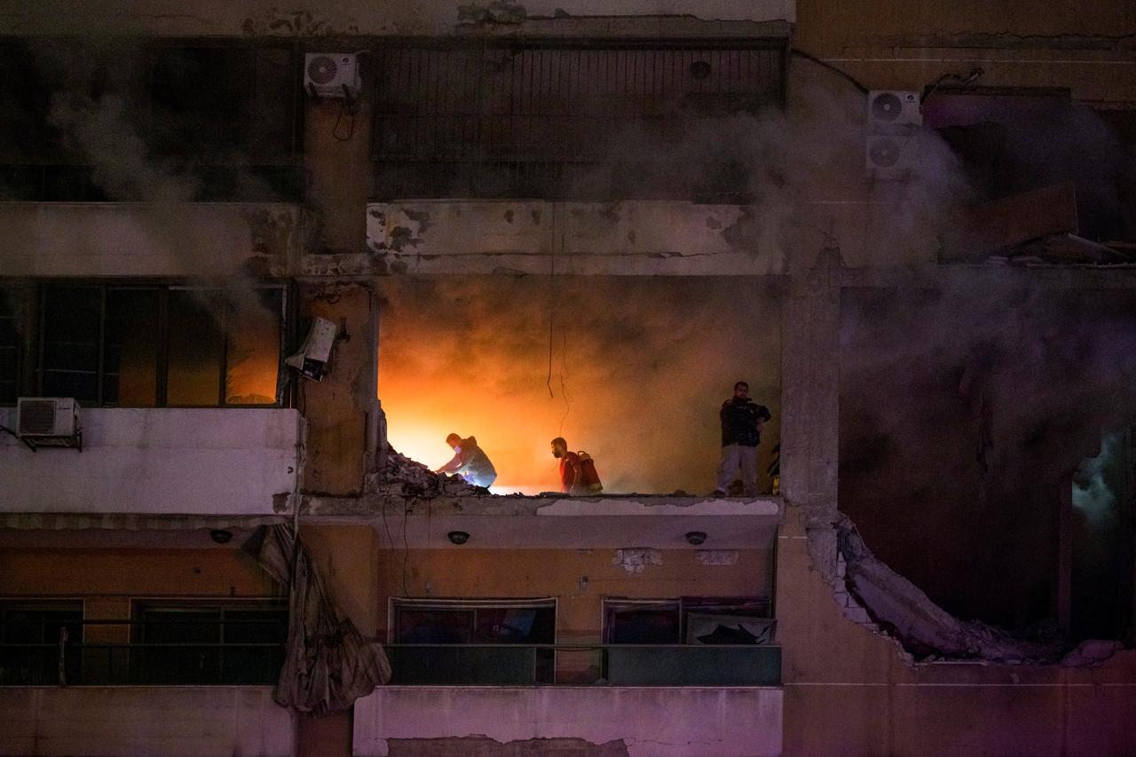 Libanesische Feuerwehrleute durchsuchen ein zerstörtes Haus in Beirut nach Überlebenden.