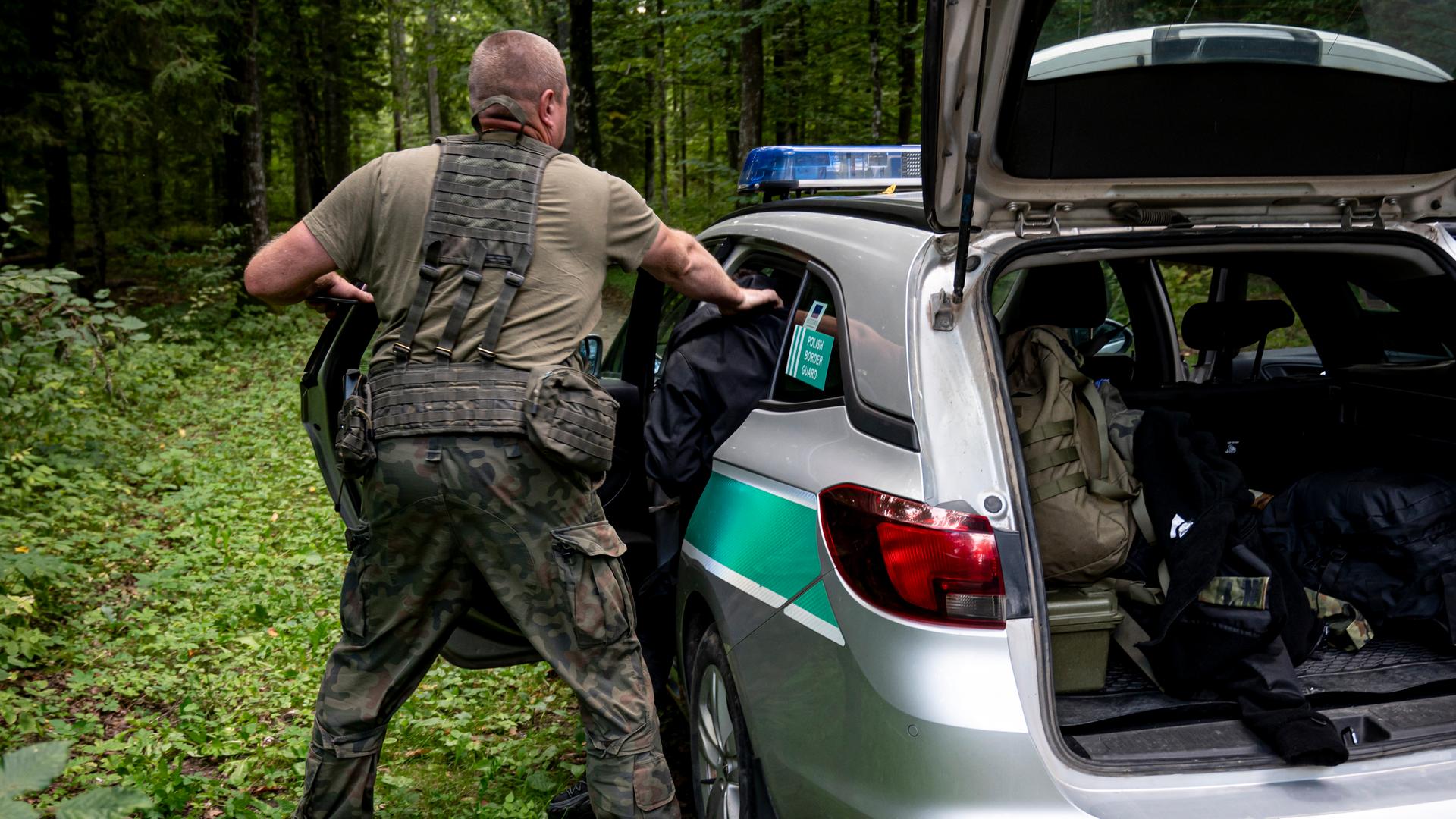 Ein polnischer Grenzschützer nimmt im Grenzgebiet zu Belarus einen Mann fest. 