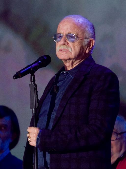 Der Liedermacher Gino Paoli in fortgeschrittenem Alter an einem Mikrophon