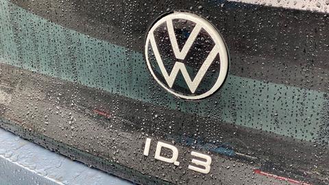 VW Logo auf einem E-Auto Modell des ID.3 mit Regentropfen