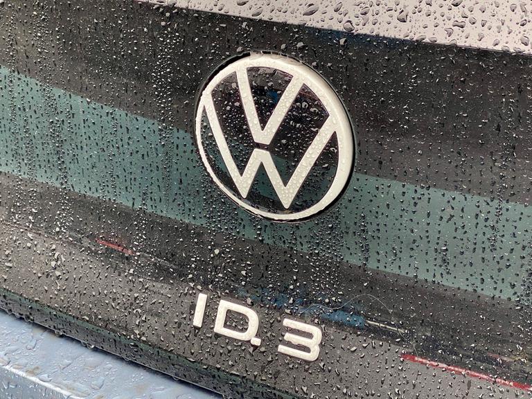 VW Logo auf einem E-Auto Modell des ID.3 mit Regentropfen