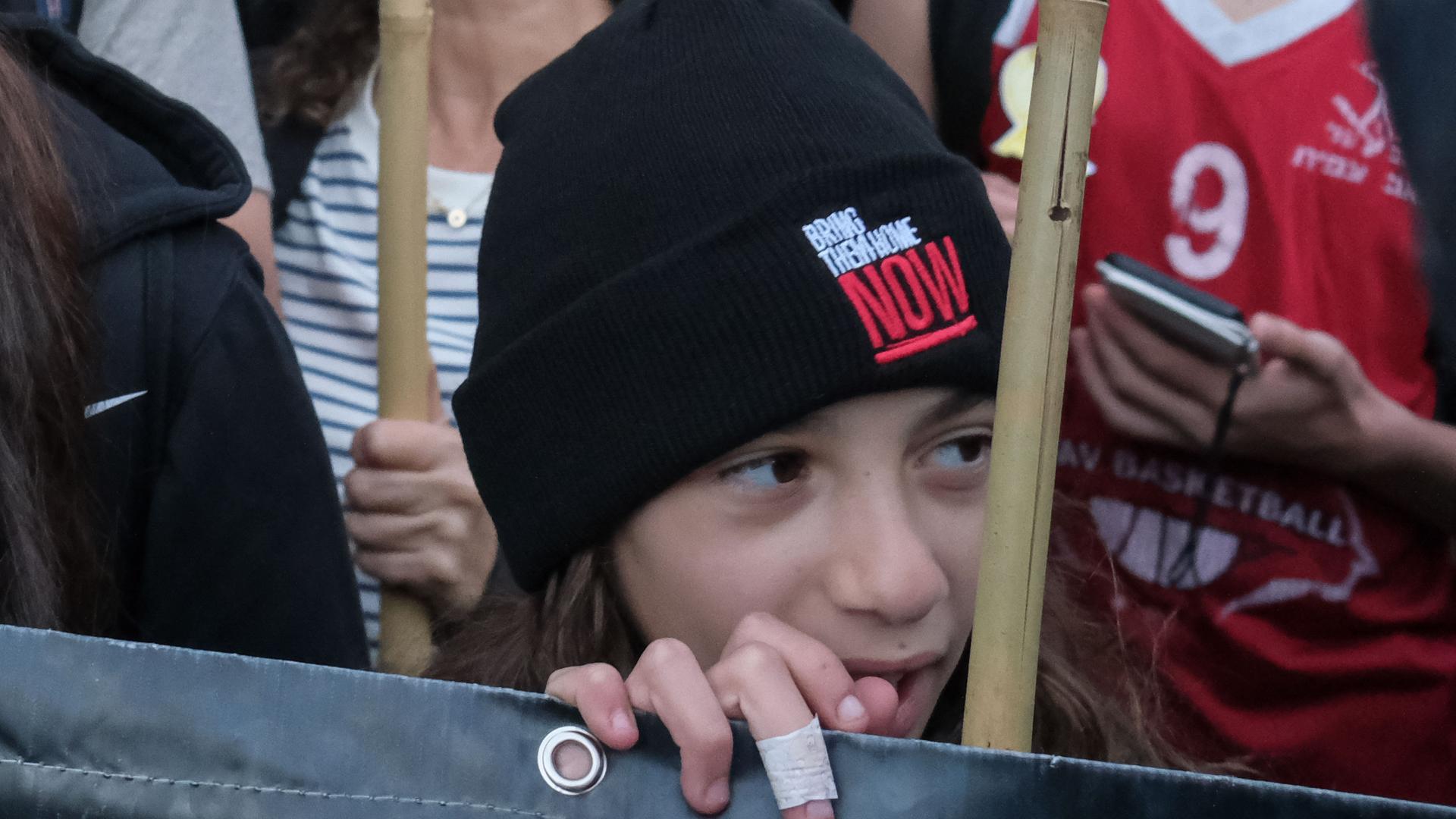 Ein Kind trägt bei einer Demonstration eine Mütze mit der Aufschrift "Bring them home NOW" - gemeint sind die von der Hamas entführten Israelis.