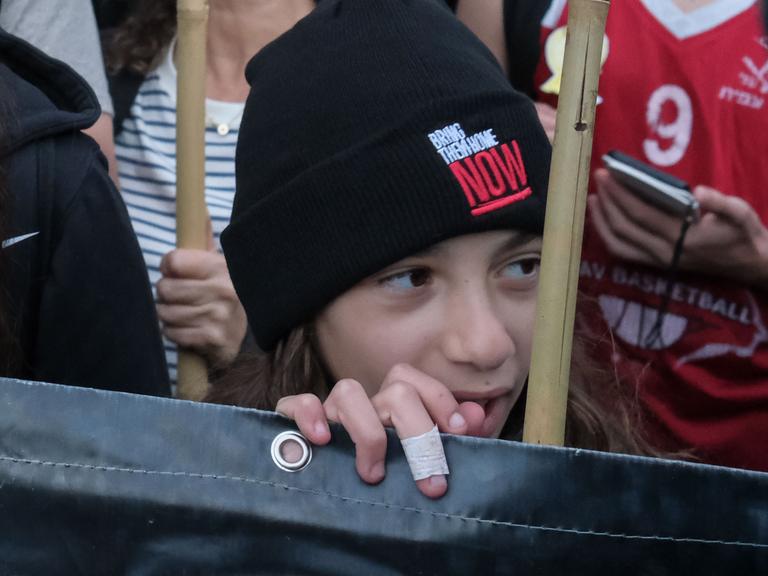 Ein Kind trägt bei einer Demonstration eine Mütze mit der Aufschrift "Bring them home NOW" - gemeint sind die von der Hamas entführten Israelis.