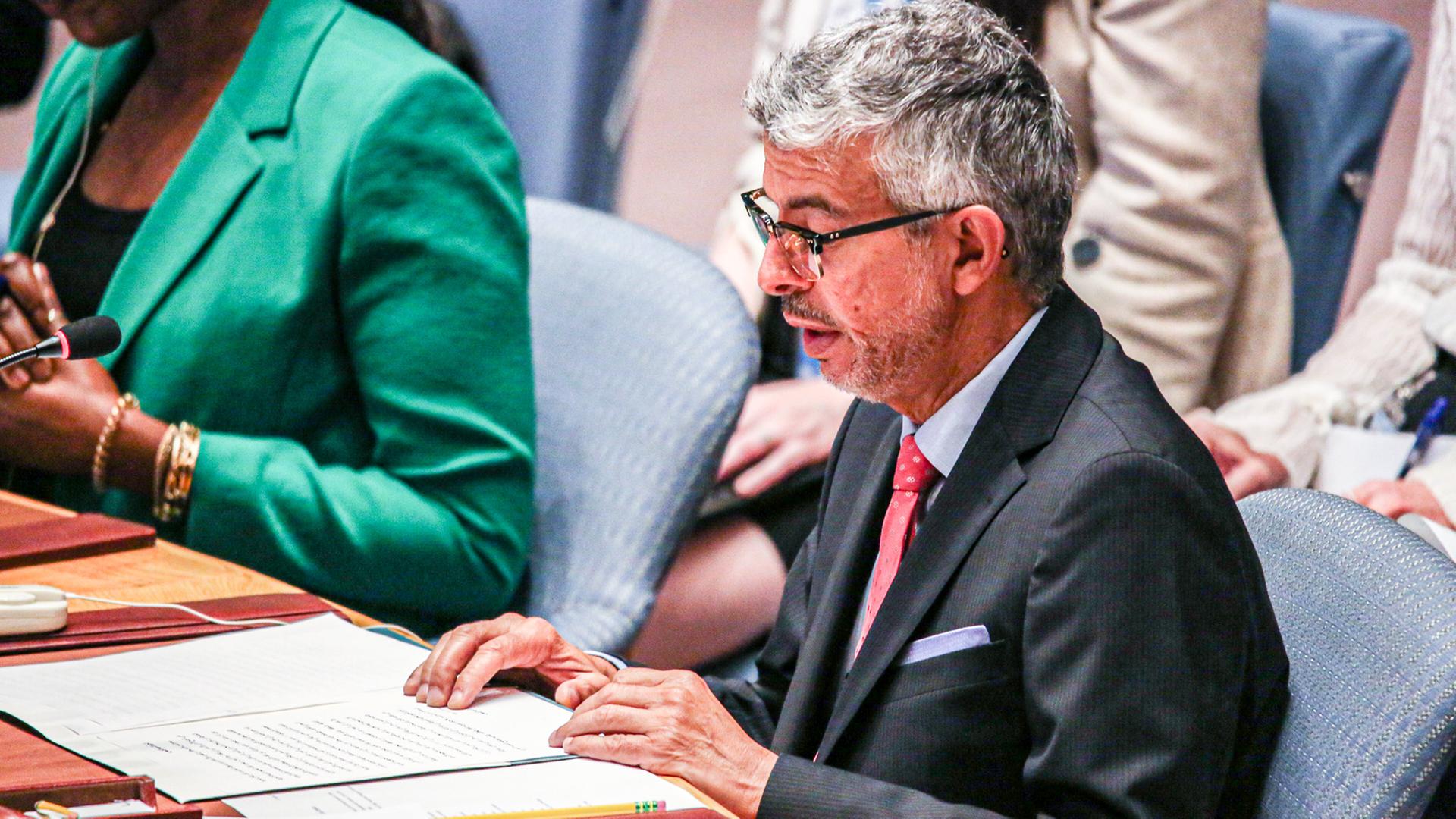 Abdulaziz Alwasil sitzt im August 2023 in einem UNO-Treffen an einem Tisch und liest in Dokumenten.