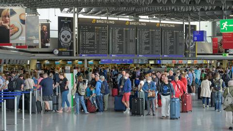 Viele Menschen warten in einer Schlange am Flughafen.