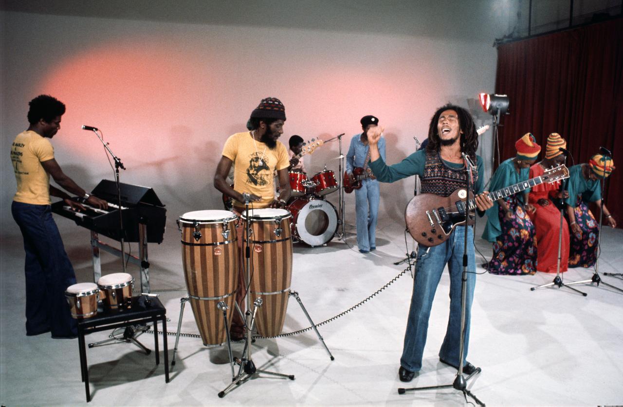 Bob Marley und seine Band auf einer Bühne.