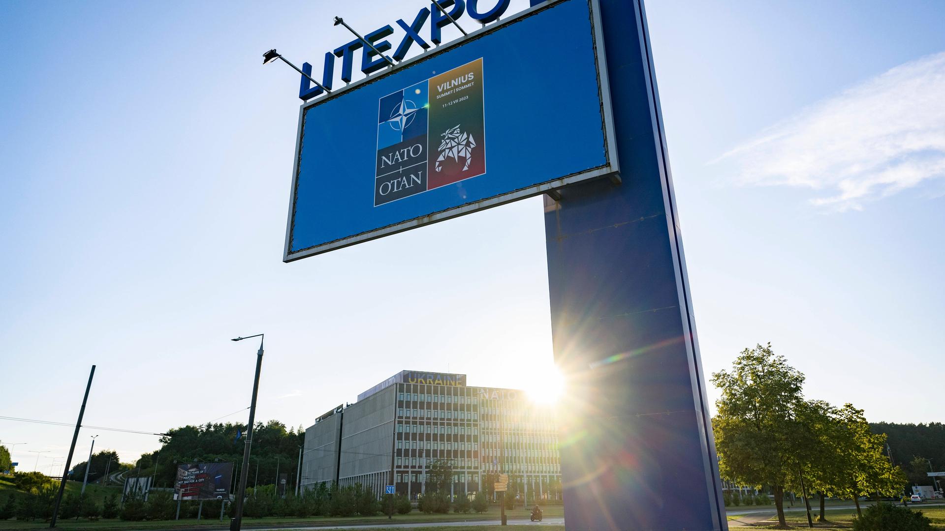 Ein Schild kündigt den NATO-Gipfel in Vilnius an. Dahinter das Gelände der Litexpo, auf dem das Treffen stattfinden wird.
