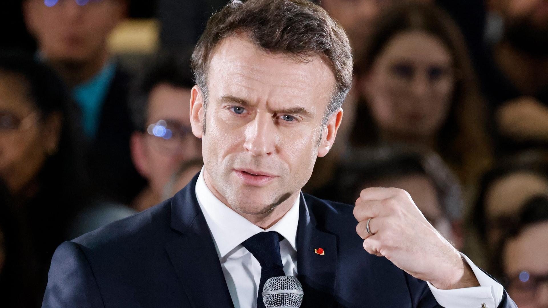 Frankreichs Präsident Emmanuelle Macron bei einer Rede am Mikrofon. Er ballt die linke Hand zur Faust.