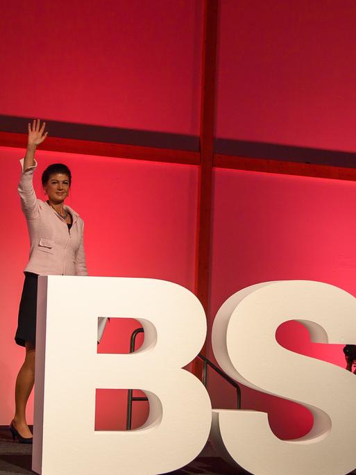 Sahra Wagenknecht steht auf der Bühne vor den Großbuchstaben BSW und winkt.