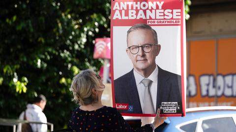 Eine ehrenamtliche Mitarbeiterin ersetzt Wahlkampfplakate des australischen Premierministers Anthony Albanese mit neuen Plakaten in seinem Wahlkreis in Sydney am 2. Mai 2025 vor den für den 3. Mai angesetzten Parlamentswahlen.