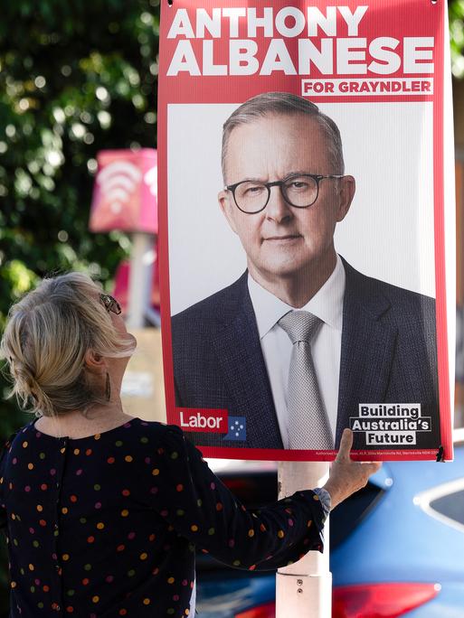 Eine ehrenamtliche Mitarbeiterin ersetzt Wahlkampfplakate des australischen Premierministers Anthony Albanese mit neuen Plakaten in seinem Wahlkreis in Sydney am 2. Mai 2025 vor den für den 3. Mai angesetzten Parlamentswahlen.