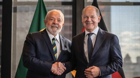 Brasiliens Präsident Lula da Silva (l.) und Bundeskanzler Scholz reichen sich die Hände.