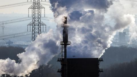 Der Schlot einer Kokerei im Ruhrgebiet stößt dichten Rauch aus. 