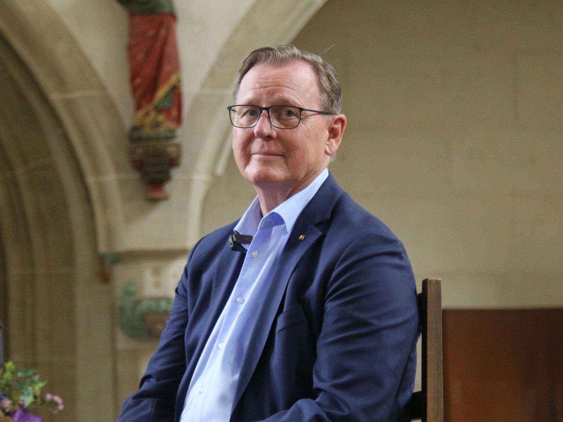 Ein Mann in blauem Jacket, der Budnestagsabgeordnete Bodo Ramelow (Die Linke) seitz auf einem Stuhl in einer Kirche