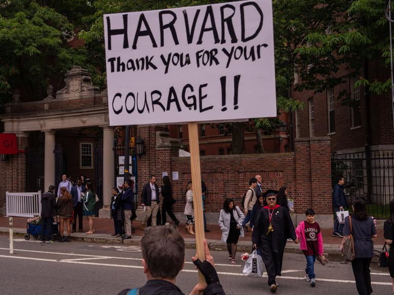 Eine Demonstration vor einem Harvard-Gebäude. Ein Schild mit der Aufschrift "Harvard, Thank you for your courage!".