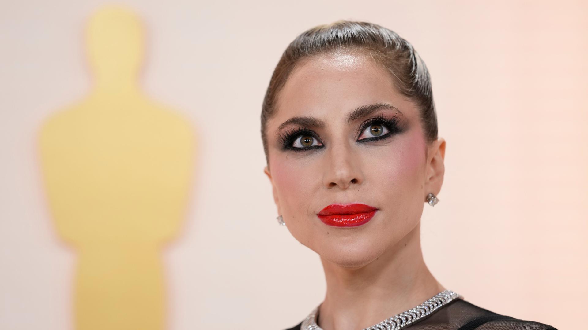 Ein Porträt der Sängerin Lady Gaga bei der Oscar-Verleihung im März 2023. Die OScar-Silhouette ist im Hintergrund zu sehen. Ein Porträt der Sängerin Lady Gaga bei der Oscar-Verleihung im März 2023. Die OScar-Silhouette ist im Hintergrund zu sehen.