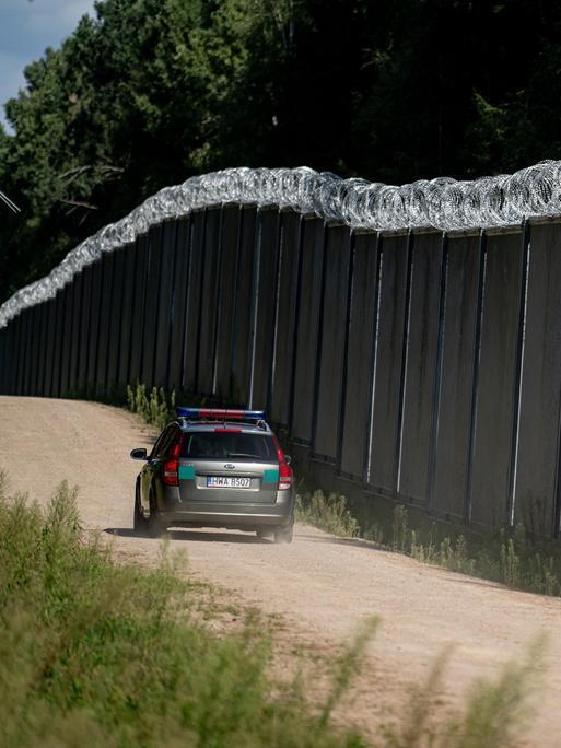 Ein Fahrzeug der polnische Grenzschützer fährt am Grenzzaun auf der polnischen Seite zu Belarus entlang. 