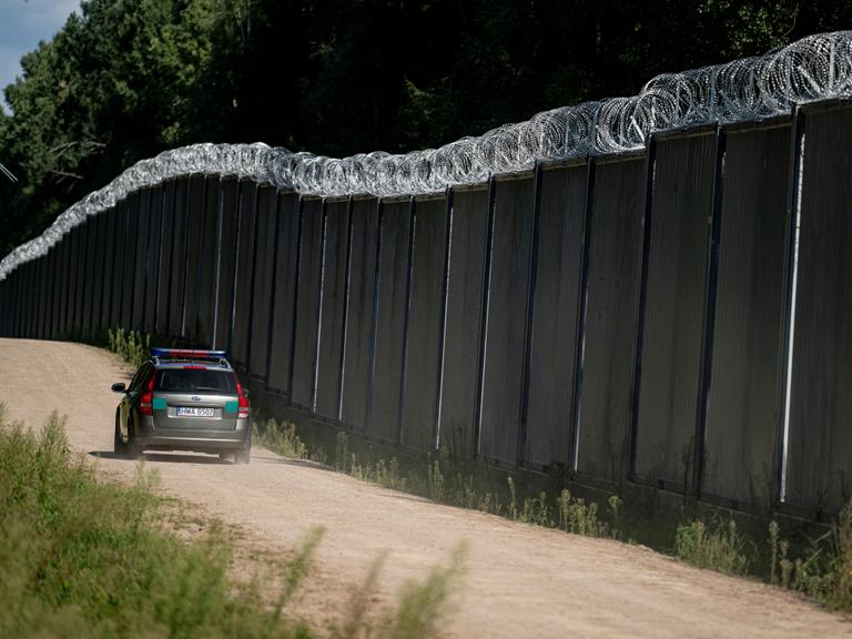 Ein Fahrzeug der polnische Grenzschützer fährt am Grenzzaun auf der polnischen Seite zu Belarus entlang. 