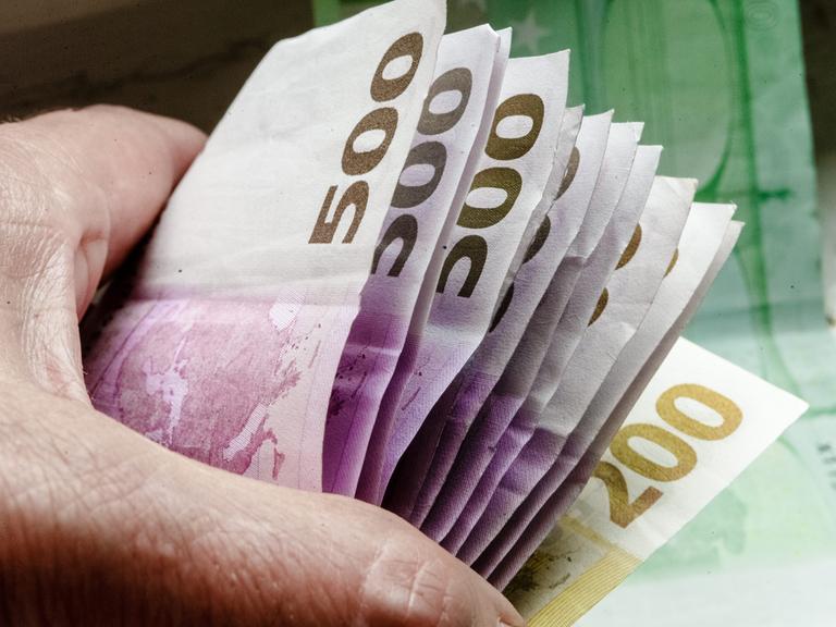 Eine Hand hält mehrere tausend Euro in 500-Euro-Scheinen. 
