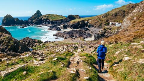 Eine Frau wandert auf dem Küstenweg von Lizard Point zur Kynance Cove in Cornwall, England (Symbolbild)