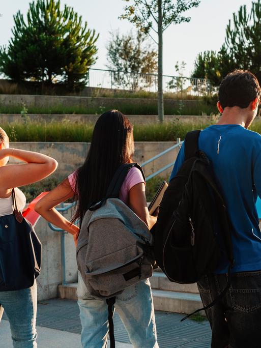 Studenten mit Rucksäcken von hinten