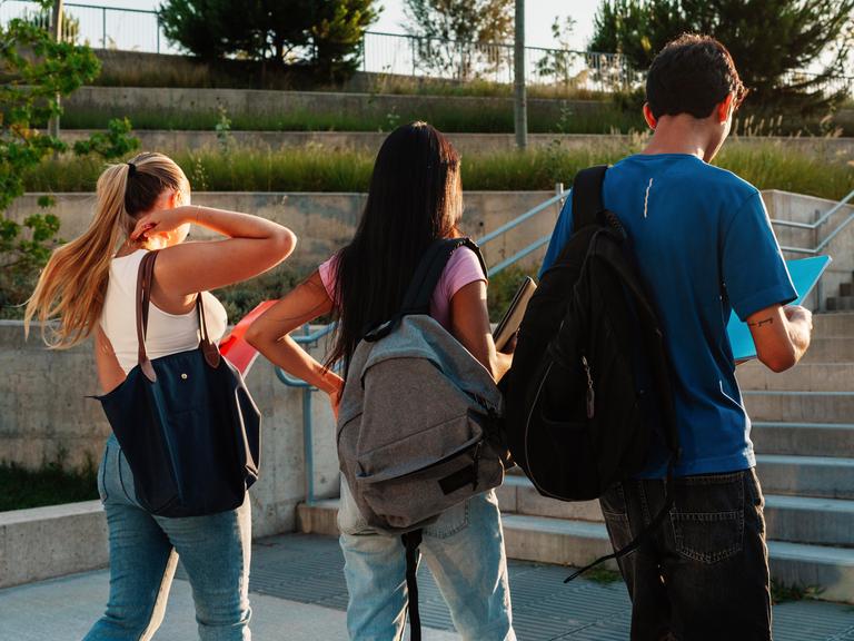 Studenten mit Rucksäcken von hinten