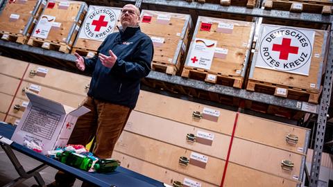 Christof Johnen, Internationale Zusammenarbeit des Deutschen Roten Kreuzes, packt ein Hygiene Kit des Deutschen Roten Kreuz (DRK) in einer Halle am Flughafen Schönefeld.
