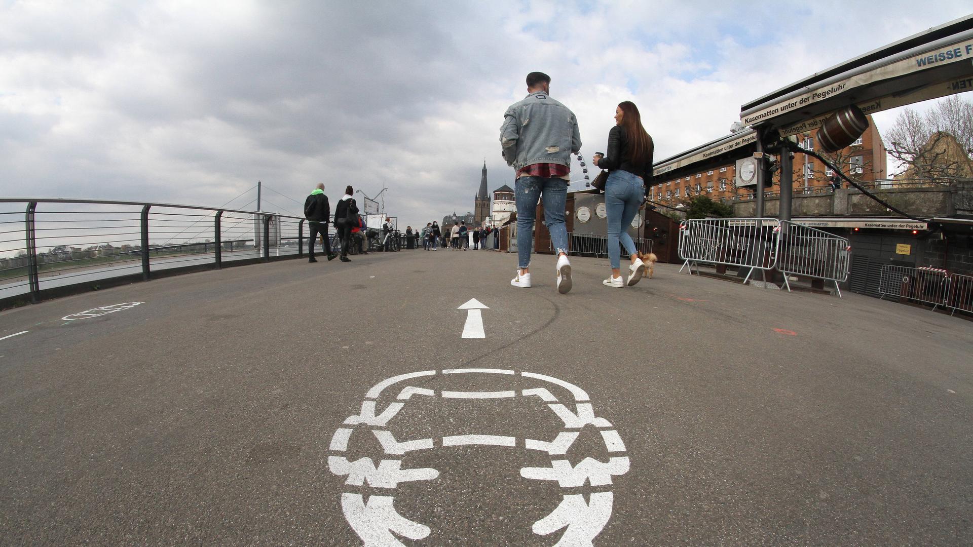 Piktogramm Maskenpflicht auf dem Pflaster der Rheinpromenade in Düsseldorf, Nordrhein Westfalen, Deutschland *** Pictogram mask obligation on the pavement of the Rhine promenade in Düsseldorf, North Rhine-Westphalia, Germany Piktogramm Maskenpflicht auf dem Pflaster der Rheinpromenade in Düsseldorf, Nordrhein Westfalen, Deutschland *** Pictogram mask obligation on the pavement of the Rhine promenade in Düsseldorf, North Rhine-Westphalia, Germany
