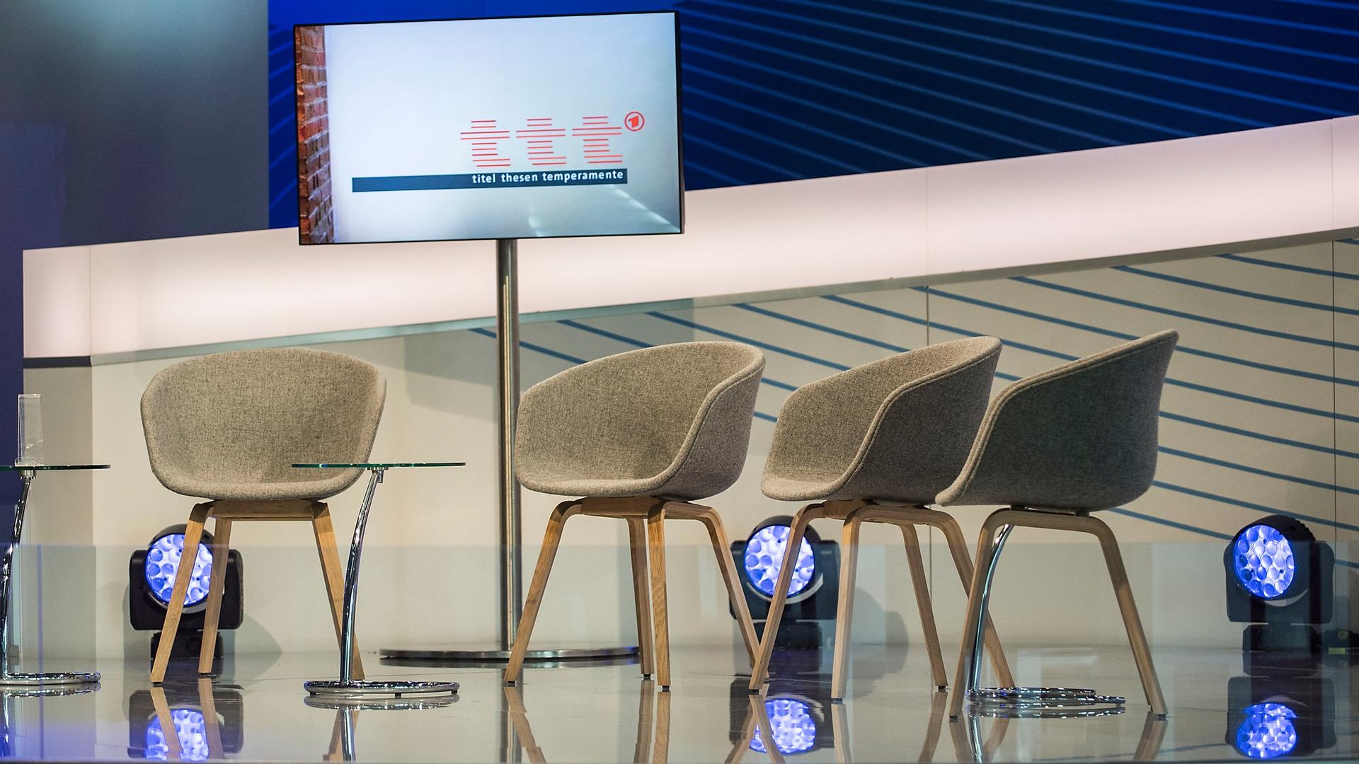 Ein leeres Fernsehstudio der ARD mit vier Stühlen auf einem Podium auf der Frankfurter Buchmesse 2017. Ein Bildschirm zeigt das Logo der Sendung "ttt - titel thesen temperamente".