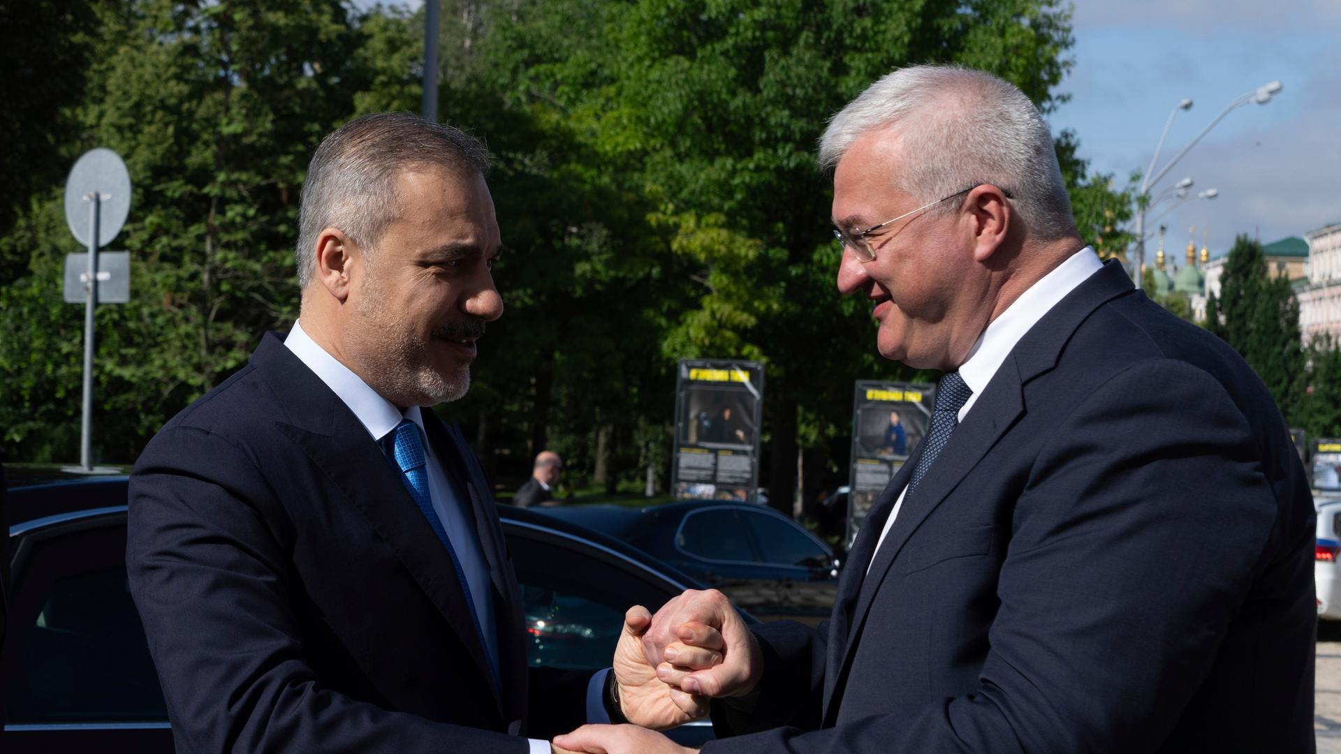 Der türkische Außenminister Hakan Fidan (l) und sein ukrainischer Amtskollege Andrii Sybiha (re) schütteln sich die Hände.