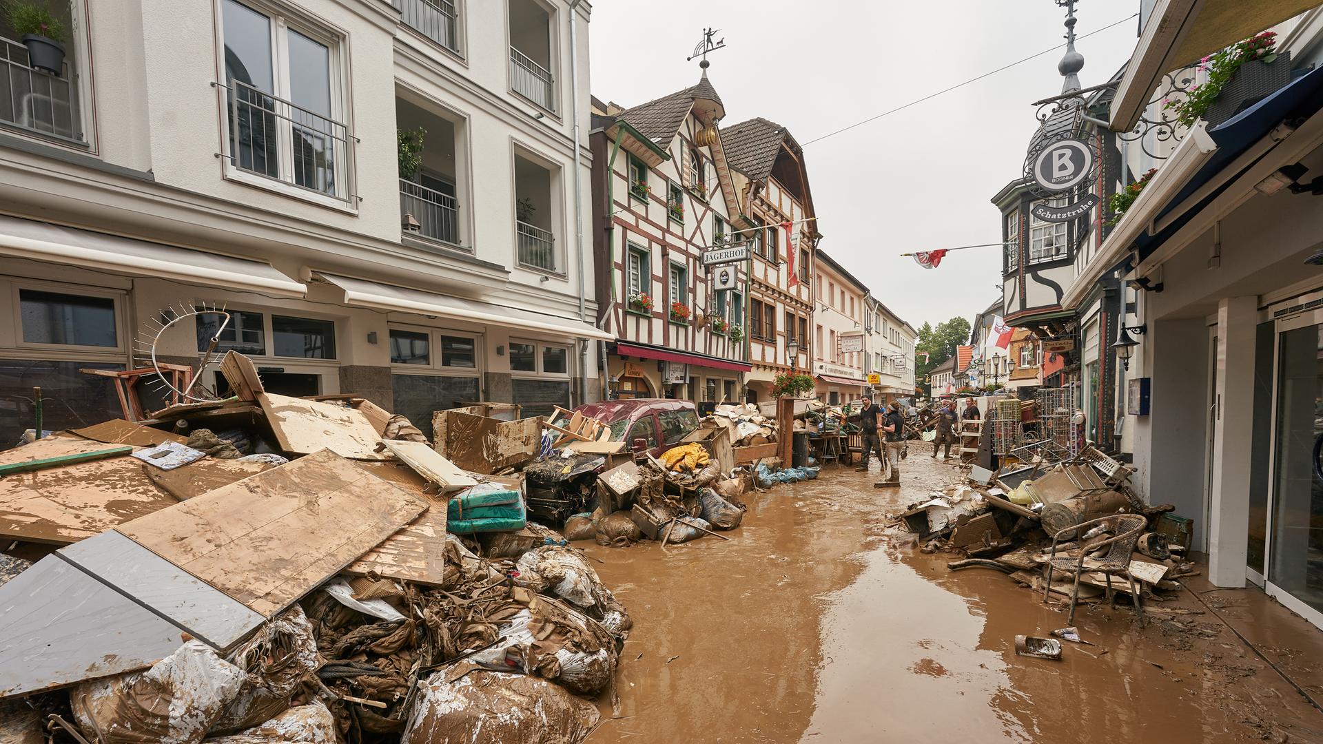 Anwohner und Ladeninhaber versuchen, ihre Häuser vom Schlamm zu befreien und unbrauchbares Mobiliar nach draußen zu bringen. Anwohner und Ladeninhaber versuchen, ihre Häuser vom Schlamm zu befreien und unbrauchbares Mobiliar nach draußen zu bringen.