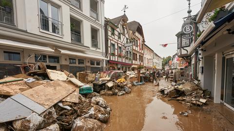 Anwohner und Ladeninhaber versuchen, ihre Häuser vom Schlamm zu befreien und unbrauchbares Mobiliar nach draußen zu bringen. 