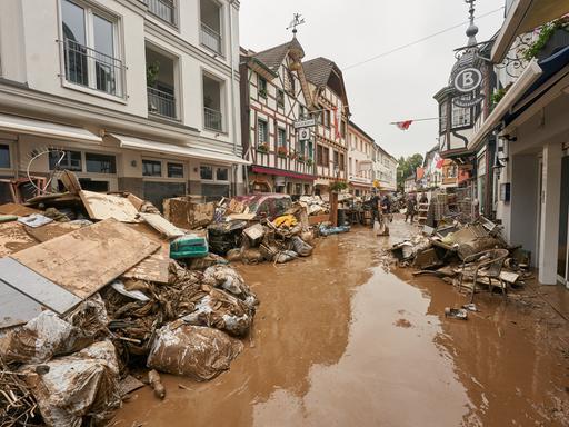 Anwohner und Ladeninhaber versuchen, ihre Häuser vom Schlamm zu befreien und unbrauchbares Mobiliar nach draußen zu bringen. 