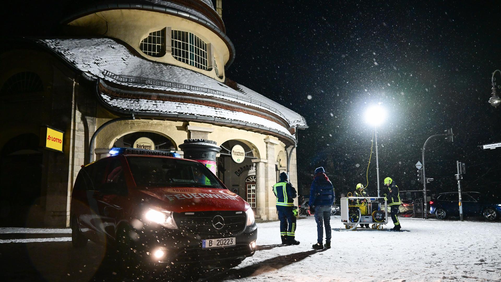 Ein Passant steht während eines Stromausfalls im Südwesten Berlins im Licht eines Hilfepunkts der Feuerwehr. Ein Passant steht während eines Stromausfalls im Südwesten Berlins im Licht eines Hilfepunkts der Feuerwehr.