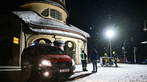 Ein Passant steht während eines Stromausfalls im Südwesten Berlins im Licht eines Hilfepunkts der Feuerwehr.
